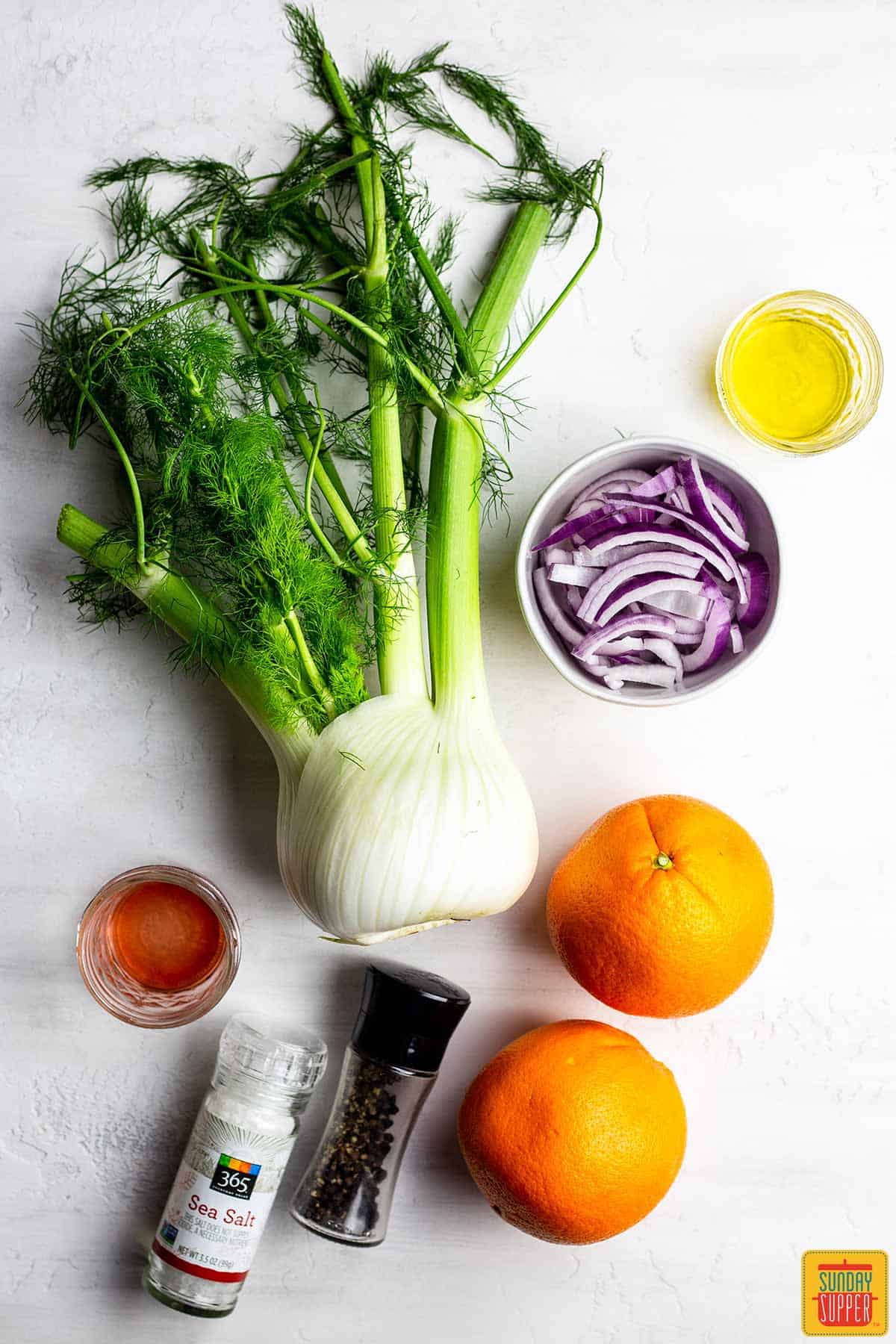 Ingredients for orange and fennel salad on a white background