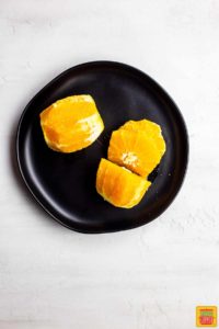 Fresh cut oranges on a black plate