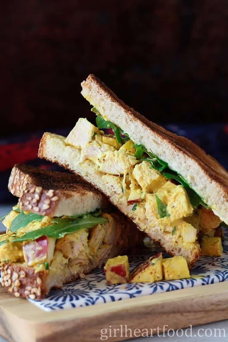 Curry chicken salad sandwiches on a cutting board by Girl Heart Food