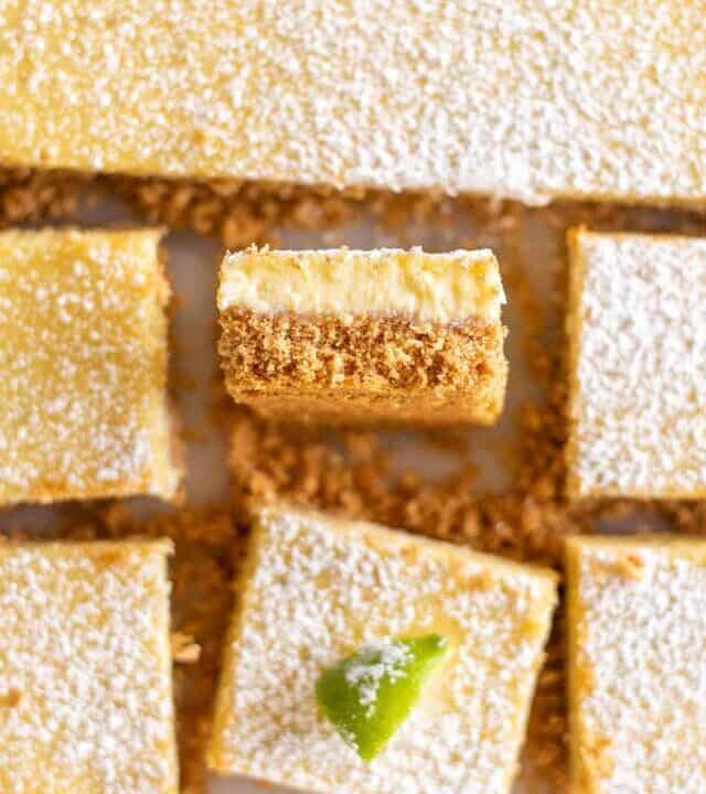 Top-down view of key lime pie squares; one is turned so you can see the crust-to-filling ratio