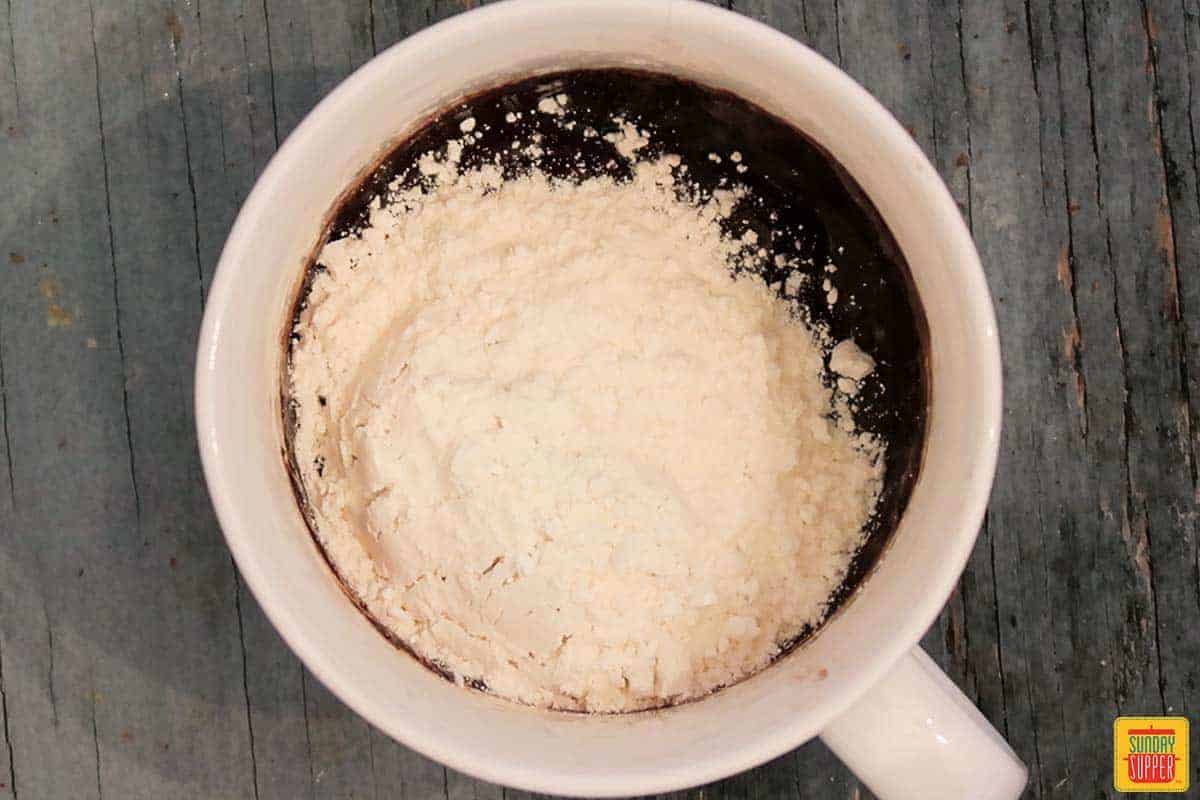 Adding flour to brownie mug cake