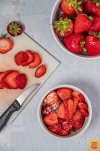 fresh strawberries cut on a gray surface