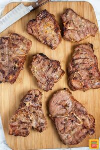 A cutting board of grilled lamb chops ready to serve