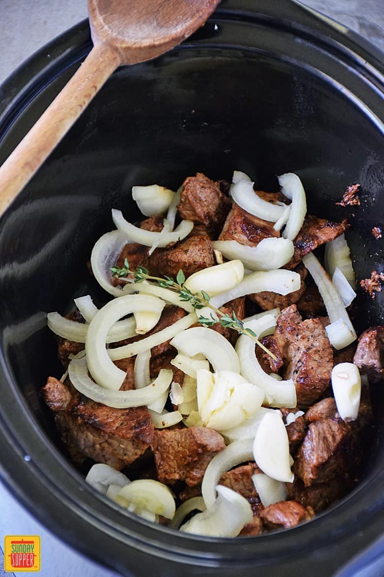 Beef tips, onions, garlic, and thyme in slow cooker