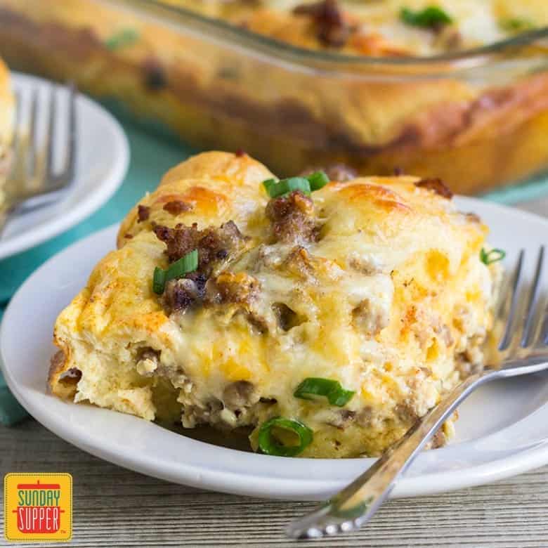 A slice of sausage breakfast casserole with crescent rolls on a plate with a fork 