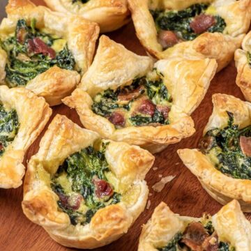 rows of spinach puff pastries on a serving board