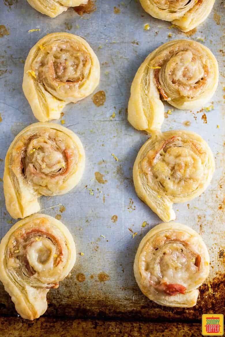 baked ham and cheese pinwheels on a baking sheet