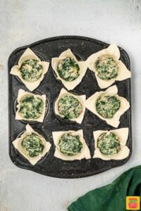 filling puff pastry cups with spinach mixture