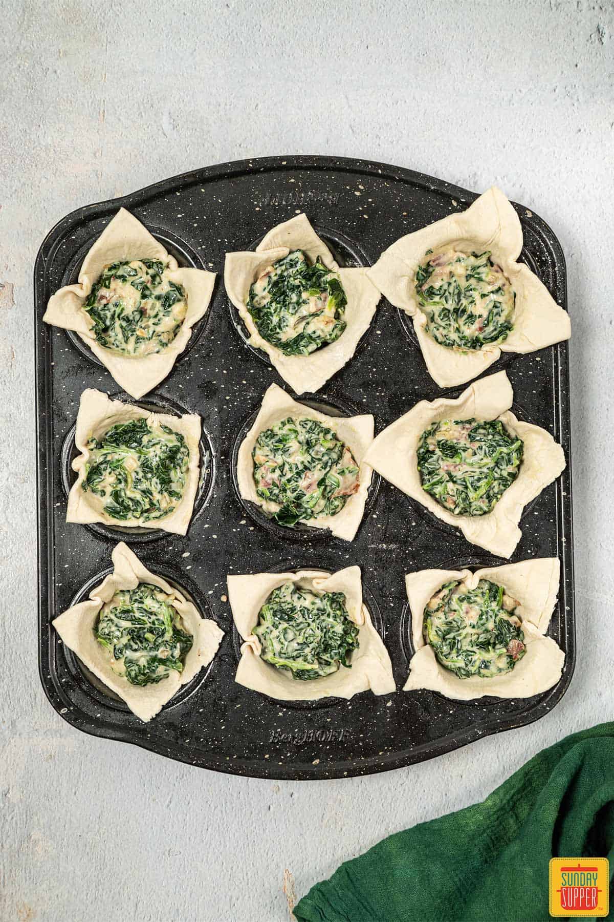 adding spinach mixture to puff pastry