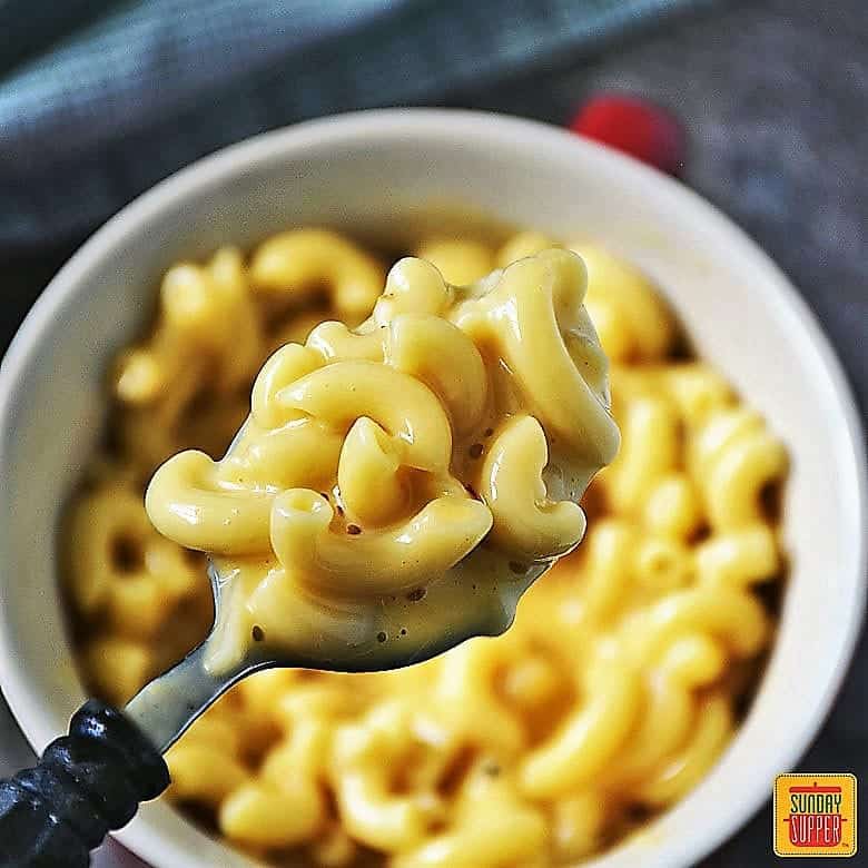 A spoonful of easy creamy mac and cheese over a white bowl