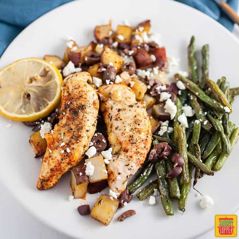 Sheet Pan Greek Chicken and Potatoes on a white plate with roasted green beans