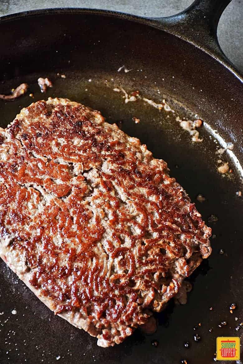 One side of ground chuck in skillet seared for ground beef stroganoff