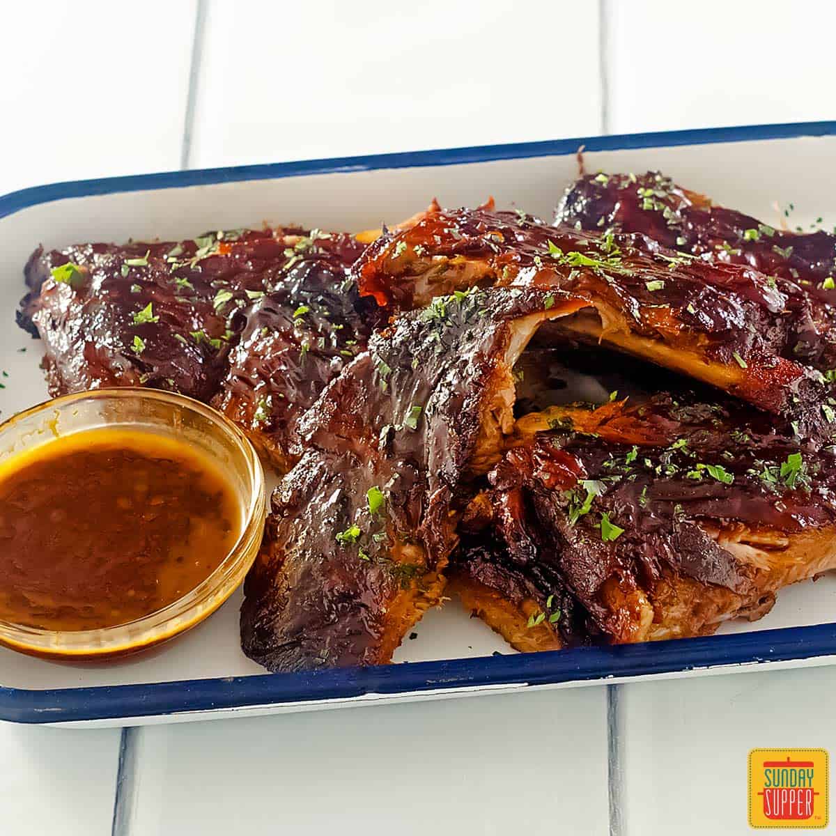 Slow cooker pork ribs on a platter with bbq sauce