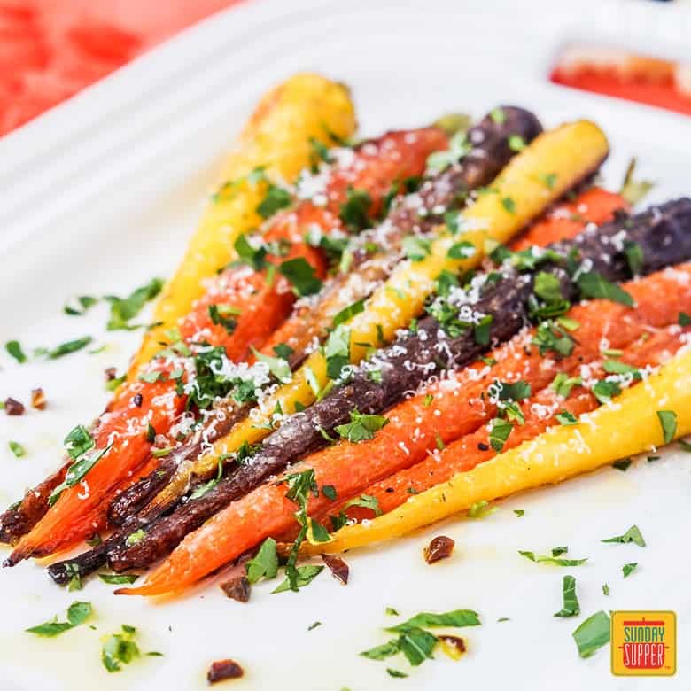 Whole Roasted Parmesan Garlic Rainbow Carrots on white serving platter