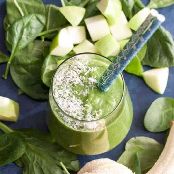 Green apple smoothie surrounded by fresh apple slices