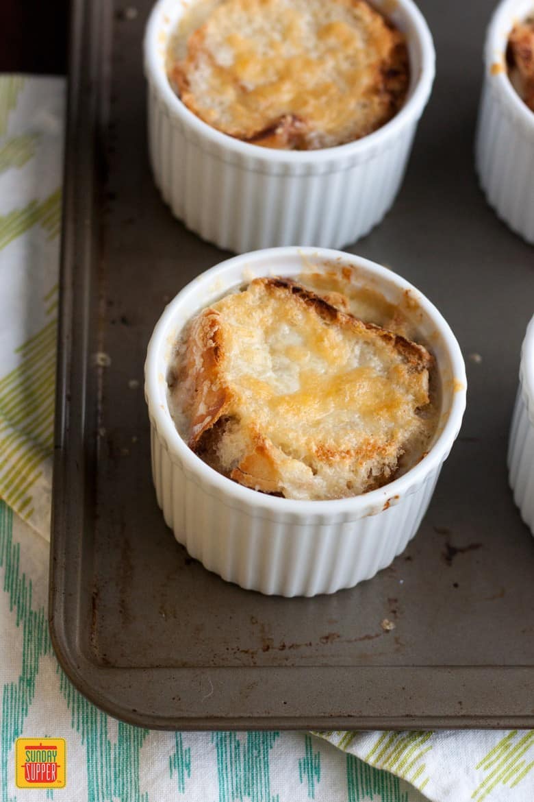 French Onion Soup in ramekins on a baking tray ready to serve with our Mushroom Grilled Cheese