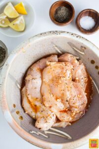 chicken marinating in a bowl