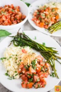 grilled chicken bruschetta on a plate with asparagus and couscous