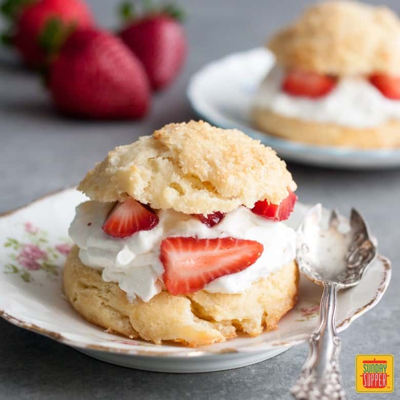 Strawberry Shortcakes on a white plate with fresh strawberries
