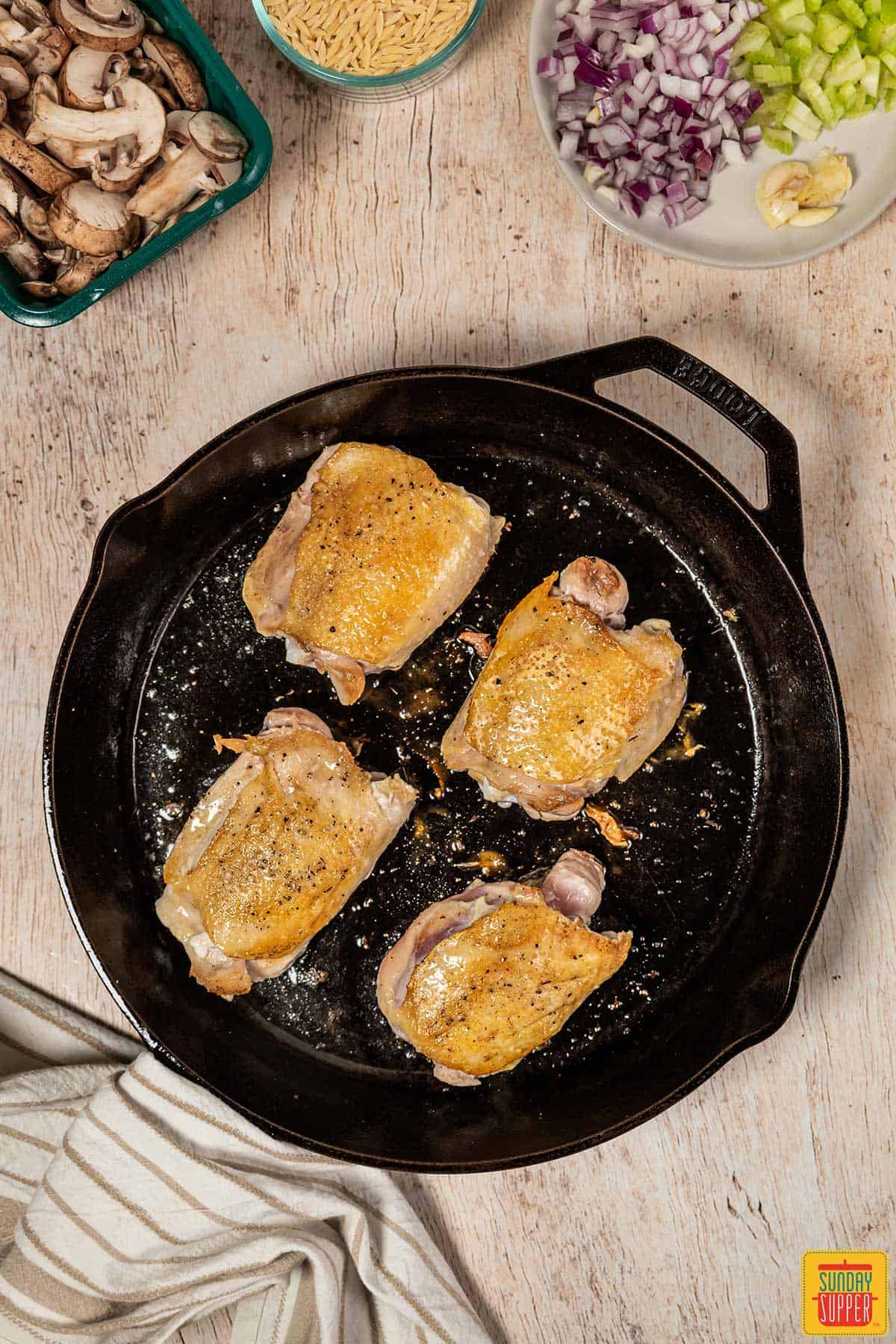 cooking chicken in a black skillet