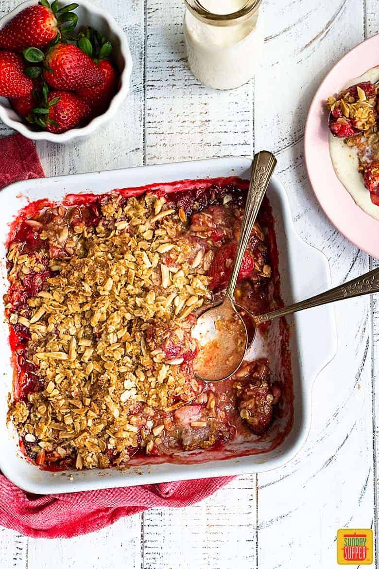overhead view of strawberry crumble in ceramic baking dish