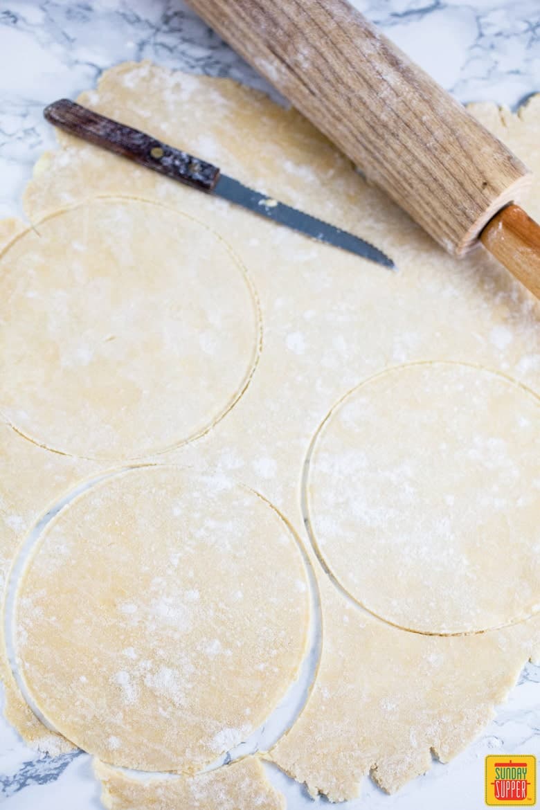 Cutting the dough discs for Puerto Rican Baked Empanadas Meat Pies