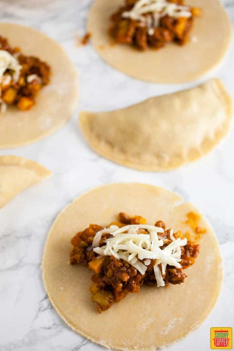 Puerto Rican Baked Empanadas Meat Pies being filled before baking