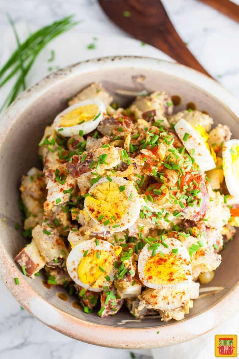 Spanish Style Potato Salad in a bowl ready to eat with fresh chives