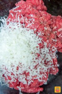 Close up of ground beef with shaved parmesan for loaded burgers