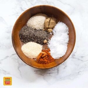 Seasoning ingredients for slow cooker brisket recipe in a wooden bowl