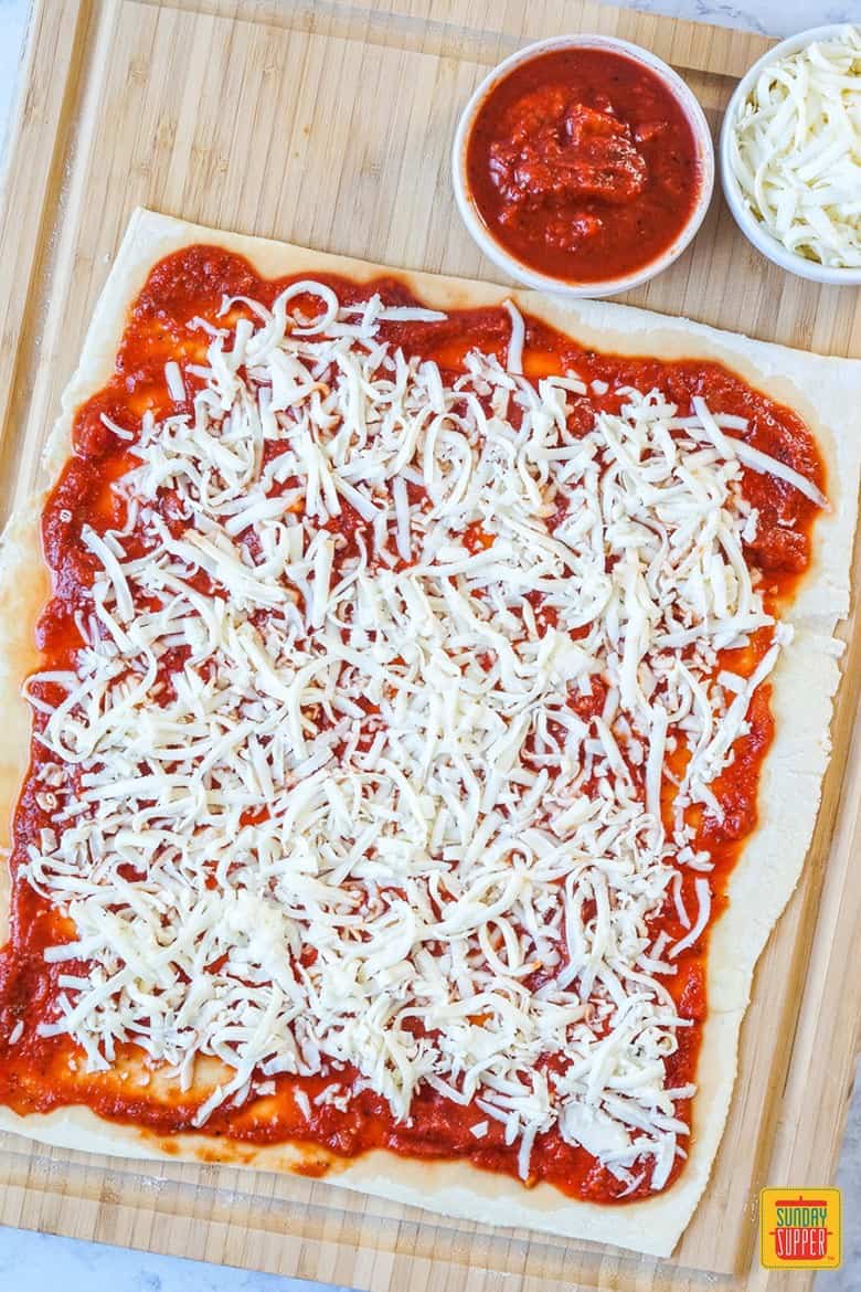 Filling the Pizza Twists with tomato sauce and cheese