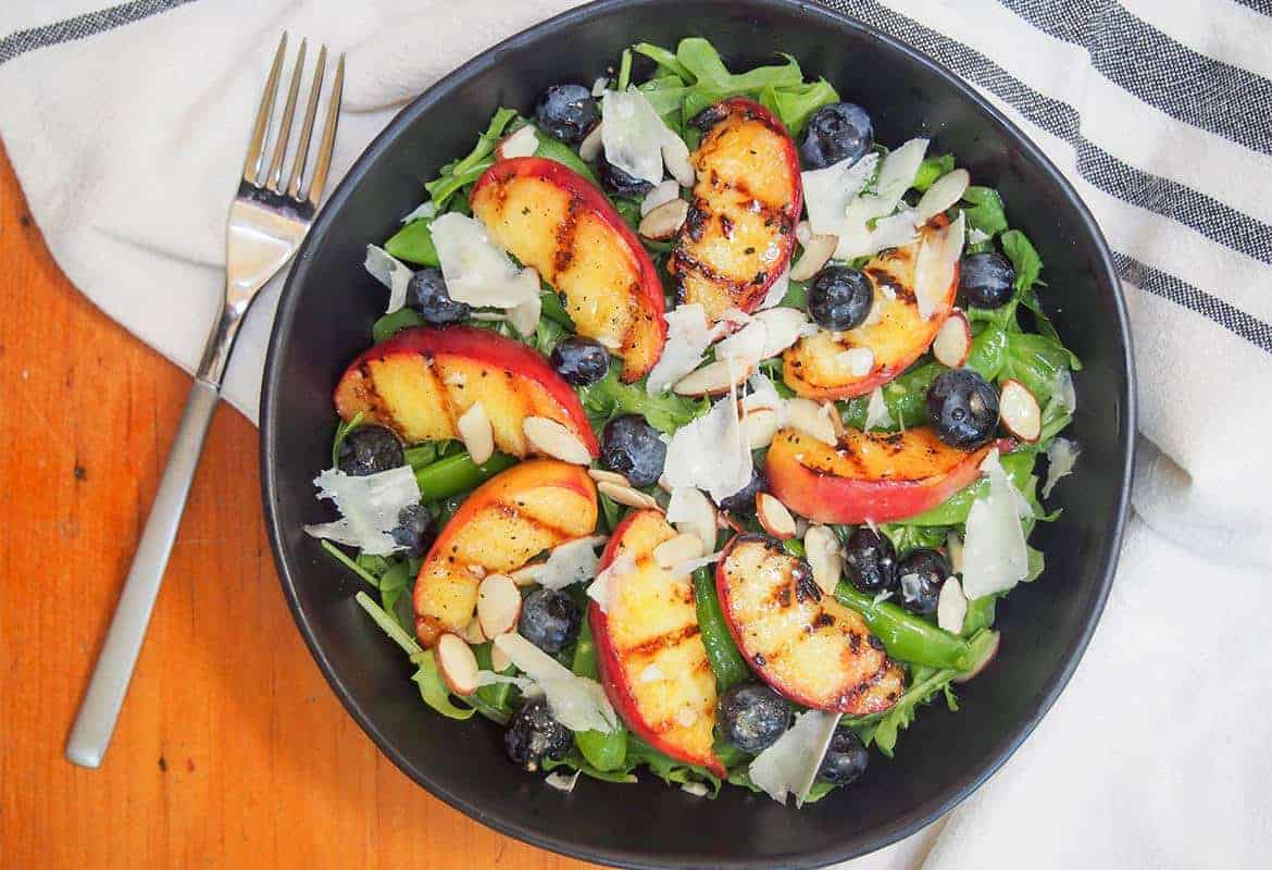 grilled peaches salad in a black bowl