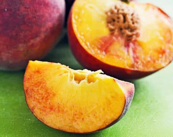 Delicious and juicy peaches on a wooden background