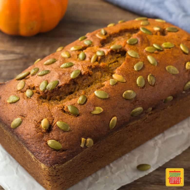 Baked Starbucks pumpkin bread recipe topped with pumpkin seeds - the whole loaf