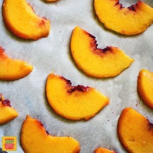 How to Freeze Peaches - sliced peaches placed on parchment lined baking sheet ready to freeze