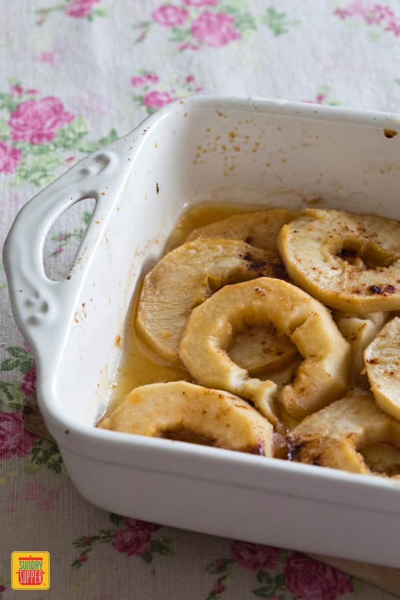 Sliced baked Apples in a pan, right after being removed from the oven