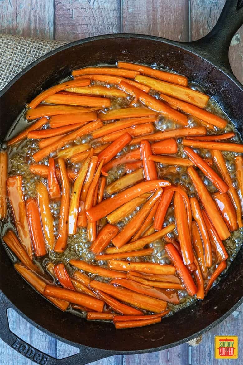 Carrots simmering in a brown sugar maple syrup glaze