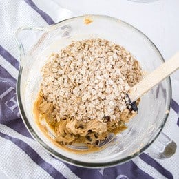 Mixing oats into oatmeal raisin cookies