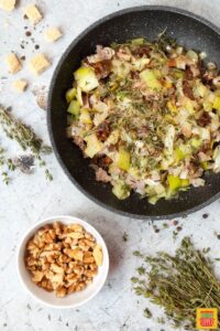 Frying onion leeks and bacon in a skillet for gluten free stuffing