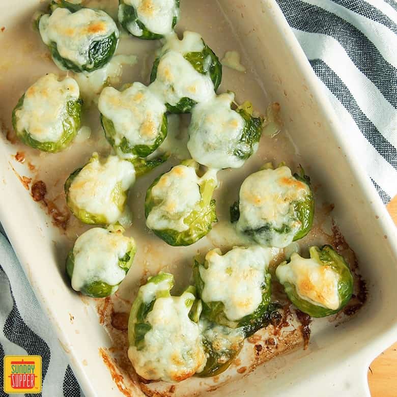 smashed Brussels sprouts in a deep white baking dish