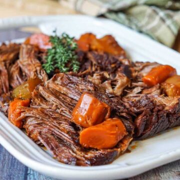 Beef chuck roast on a platter with root vegetables