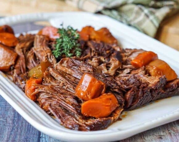 Beef chuck roast on a platter with root vegetables