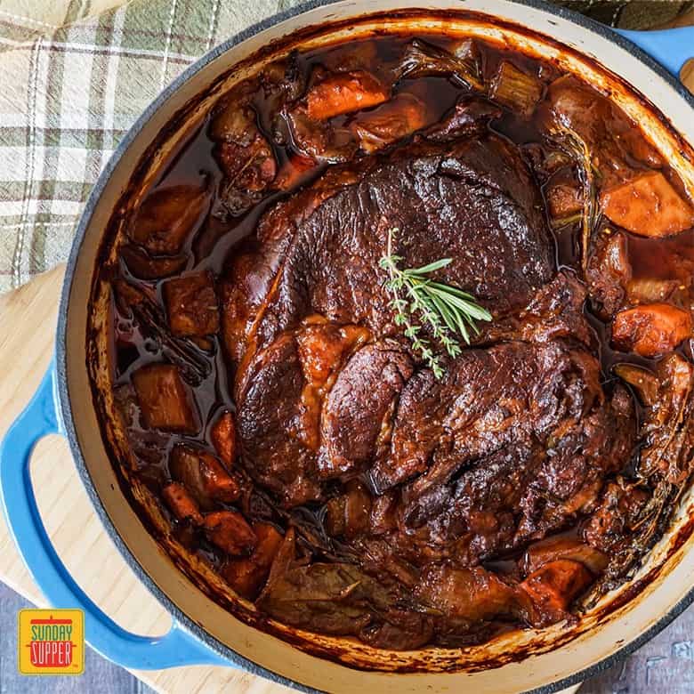 Beef chuck roast in a blue Dutch Oven