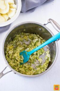 Cabbage cooking in pan with green onions