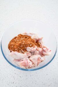 Adding spices to raw chicken wings