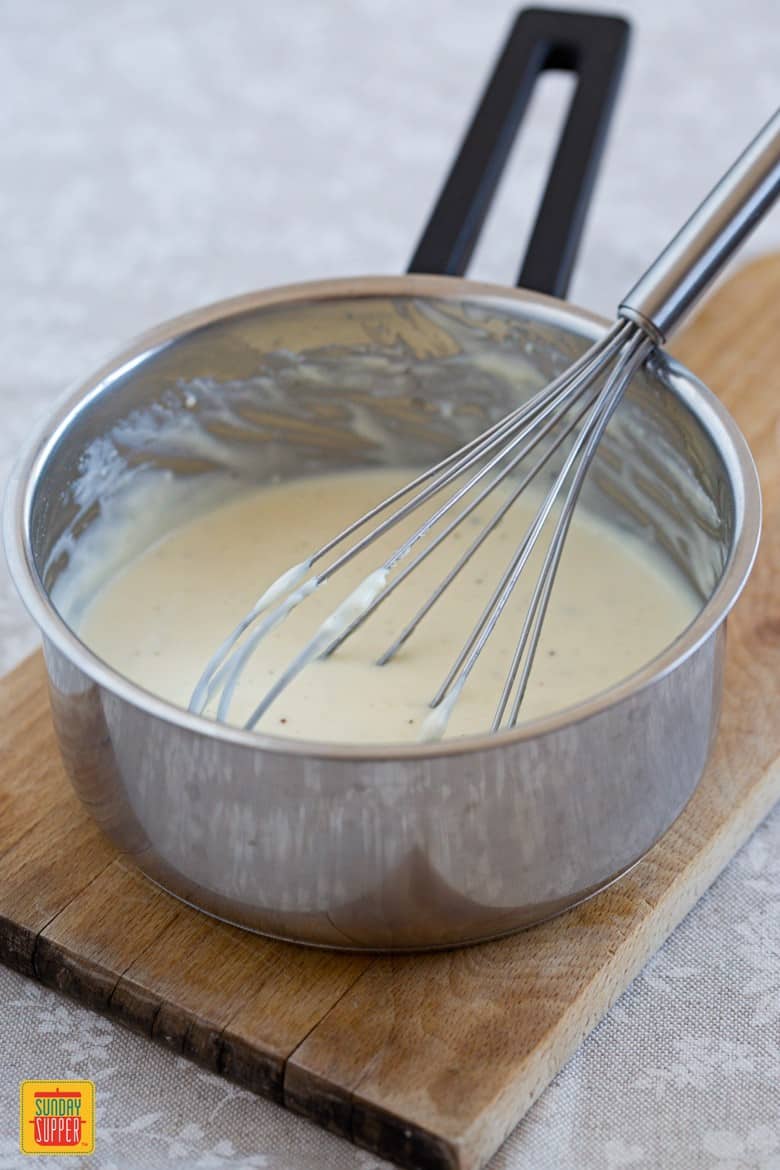 Cheese Sauce in a saucepan with a whisk