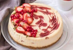 This beautiful Strawberry Swirl Cheesecake is easy to make at home and it's an absolute classic. Homemade strawberry sauce and smooth, creamy baked cheesecake. 