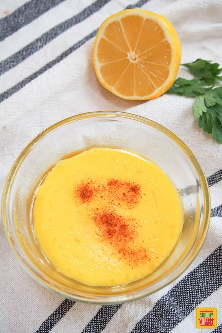 Easy Hollandaise Sauce with Cayenne in a bowl next to half a lemon