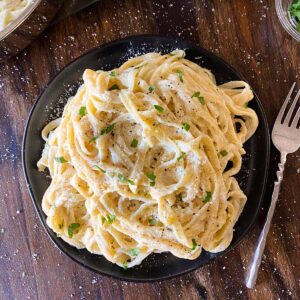 Fettuccine alfredo on a plate with a fork to the side
