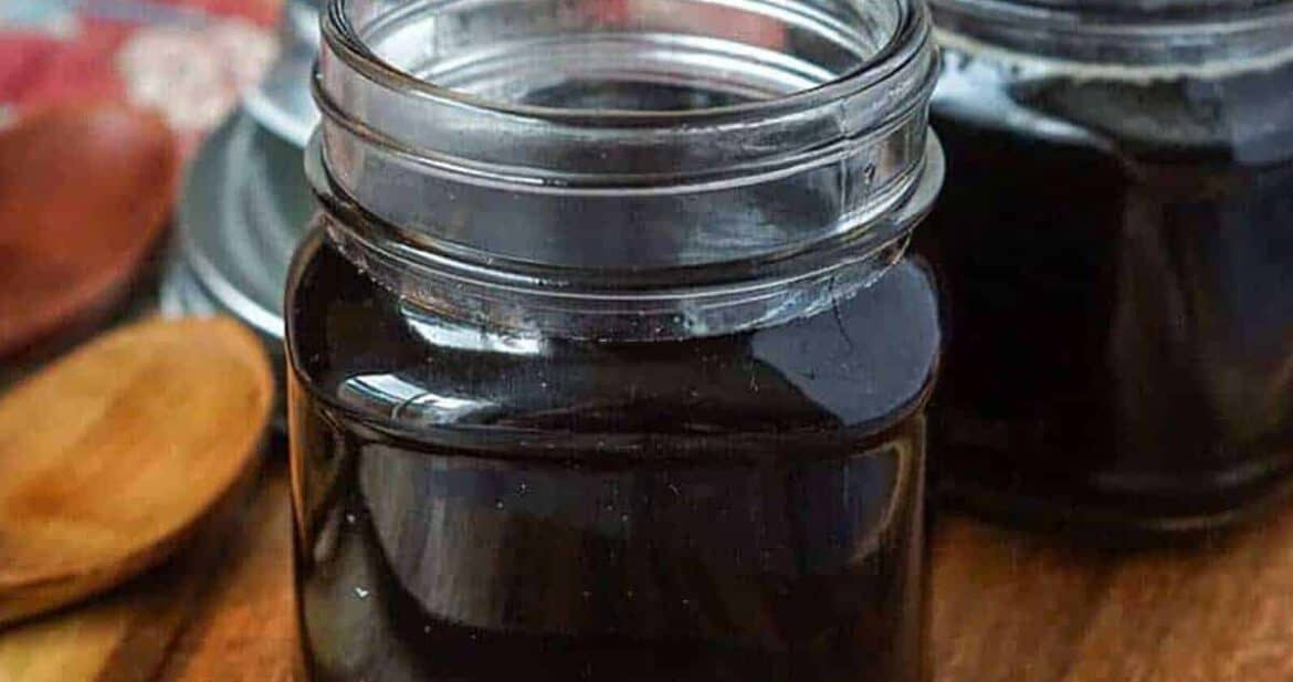 Homemade teriyaki sauce in two glass jars on a wooden surface